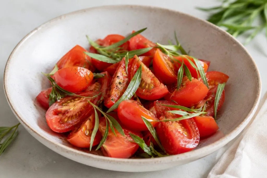Estragón con tomate en ensalada italiana con hierbas frescas y aceite de oliva para una alimentación saludable.