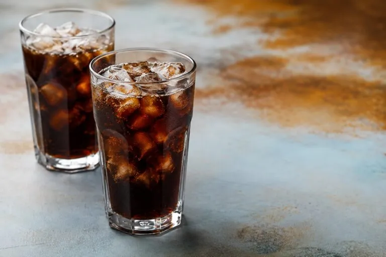 Persona sustituyendo un refresco por un vaso de agua como parte de hábitos de alimentación saludable.