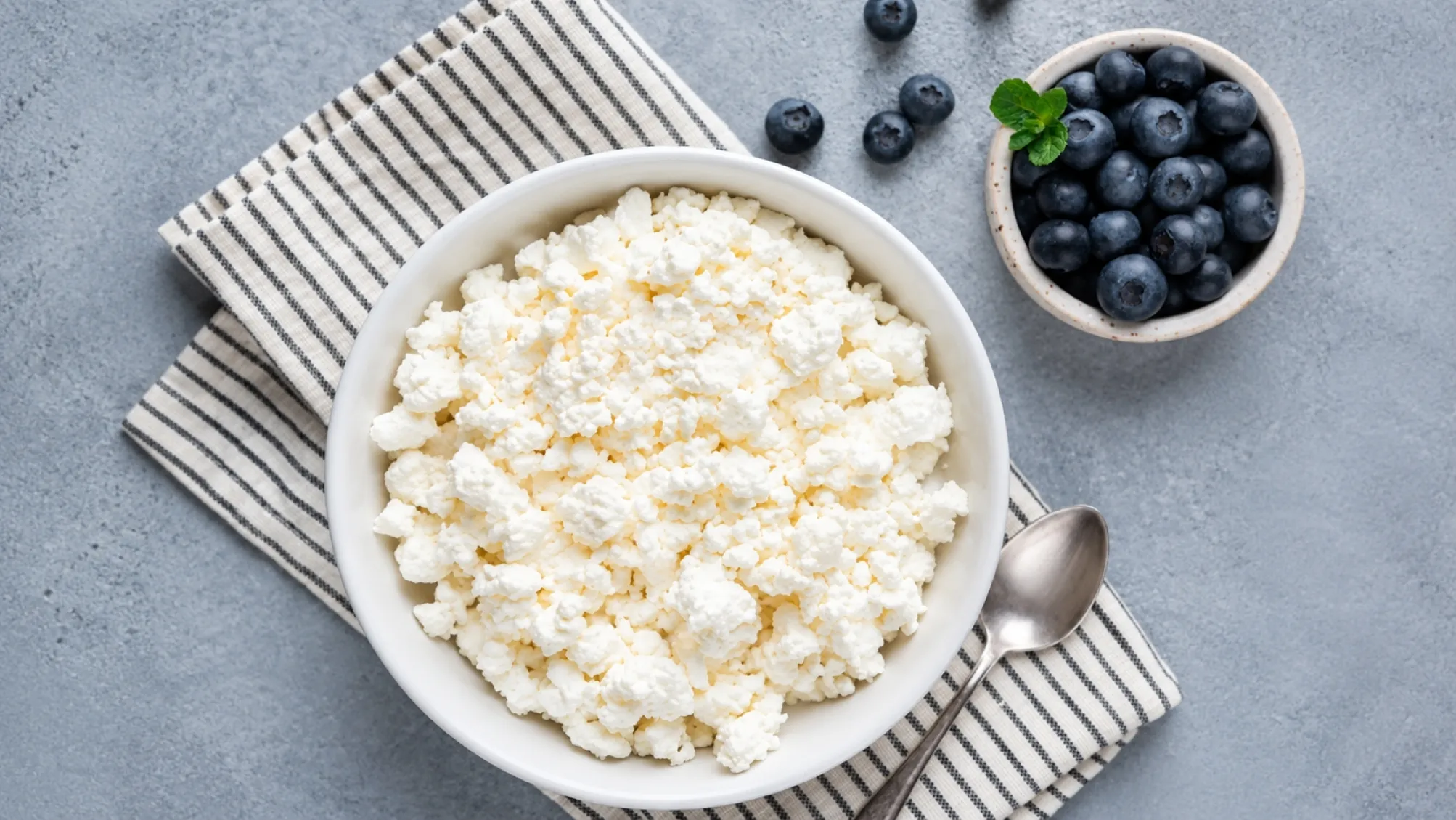 Tazón de queso cottage acompañado de ingredientes frescos para una alimentación equilibrada