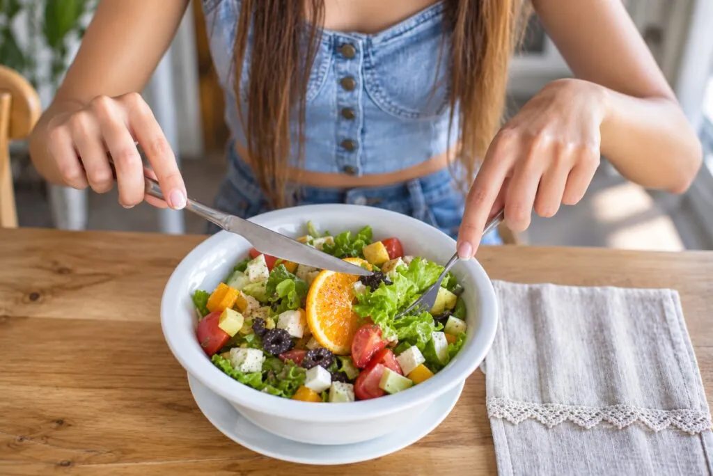 Adolescente con alimentos ricos en fibra para cuidar la microbiota mediante una dieta variada y saludable.