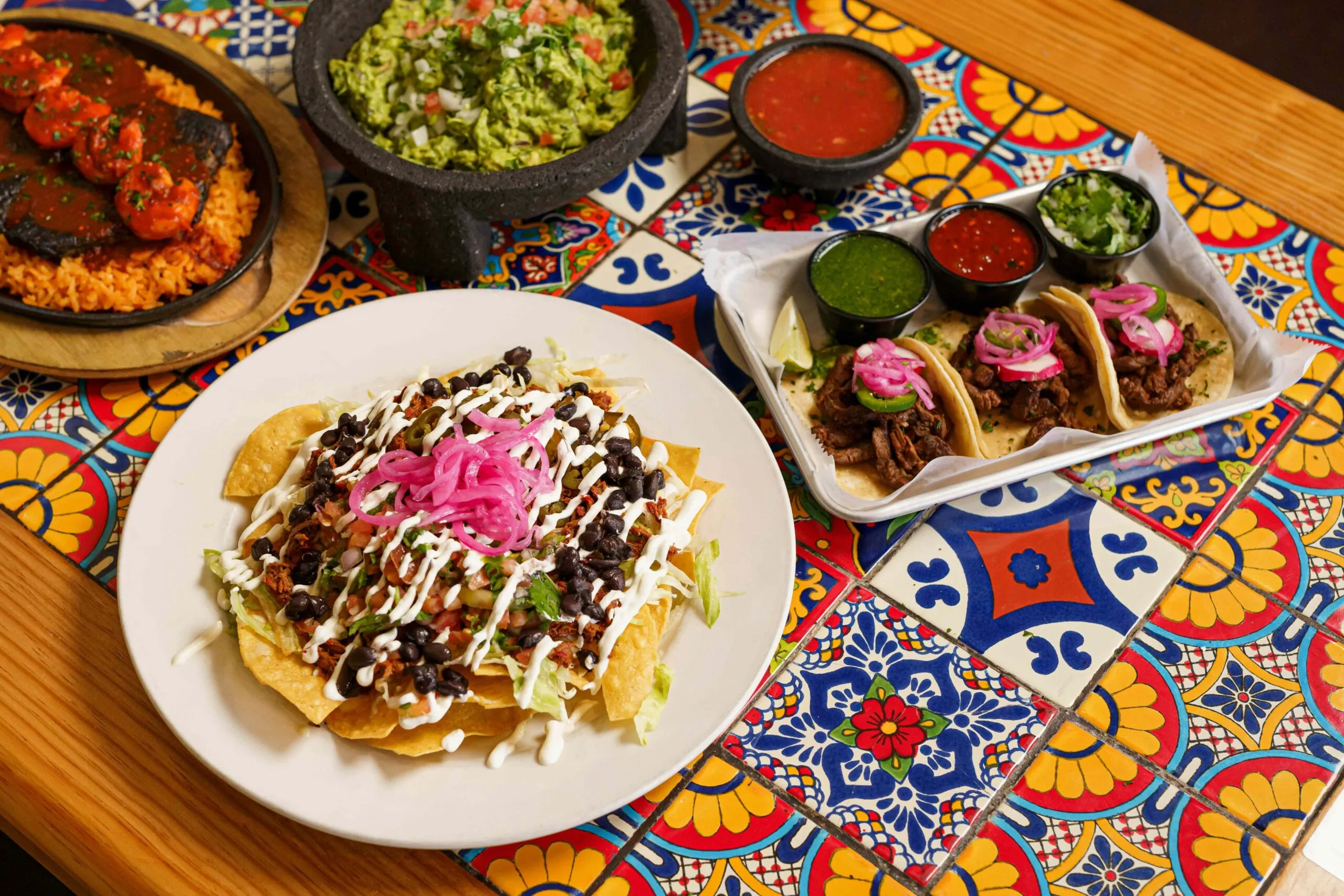 Mesa mexicana con pozole, tostadas horneadas, verduras frescas y agua de jamaica sin azúcar.