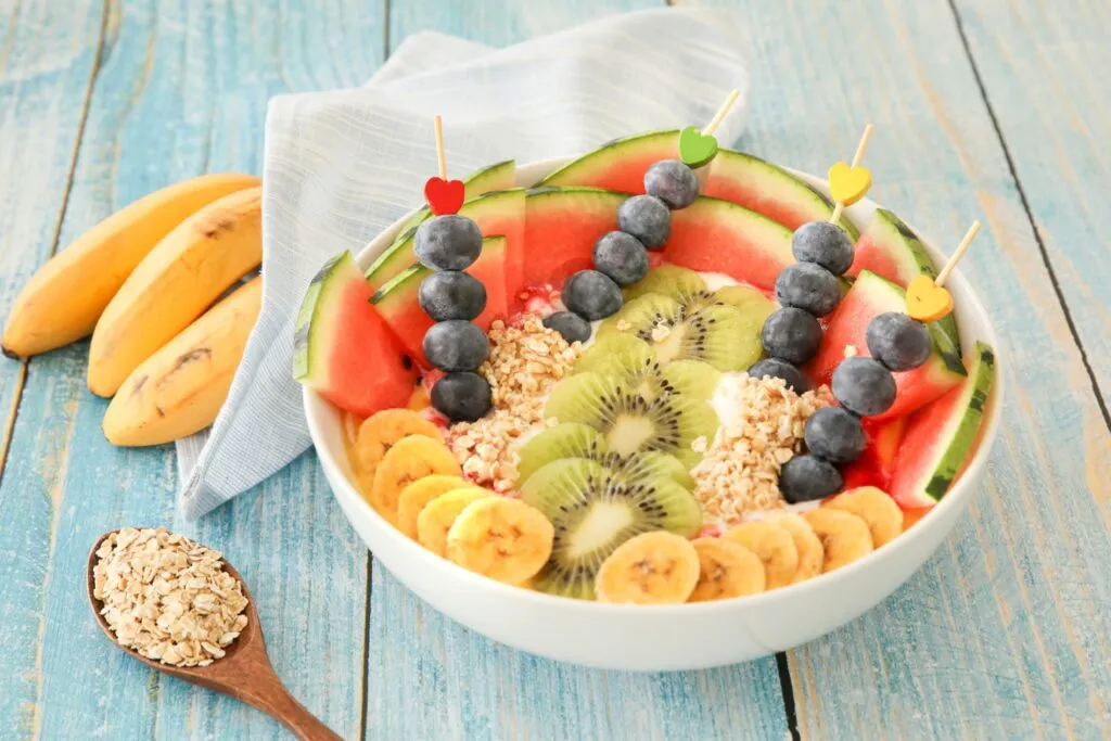 Selección de frutas enteras con fibra, agua y nutrientes para complementar una alimentación equilibrada mediante porciones saludables.