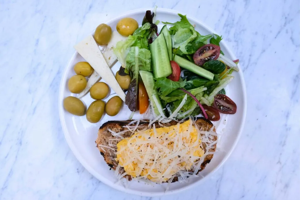 Plato equilibrado con verduras, frutas, proteínas y cereales integrales para una alimentación variada