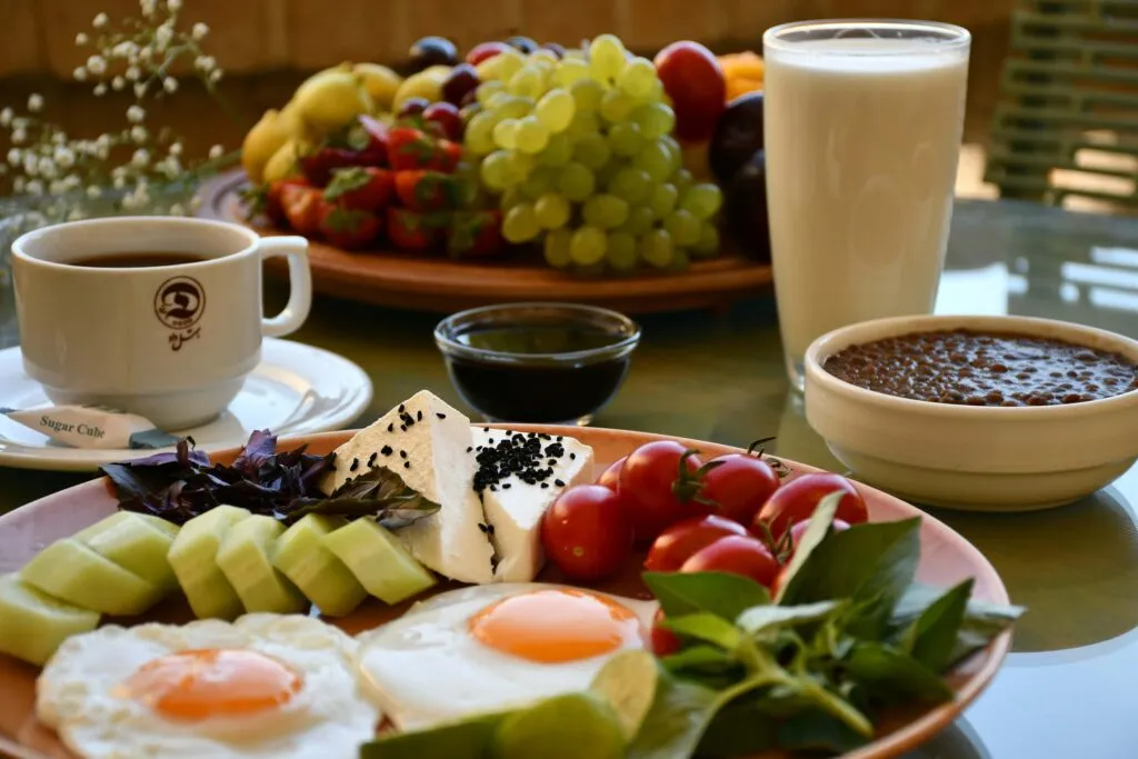 Desayuno equilibrado con huevos, fruta, pan integral y verduras para aportar proteína, fibra y otros nutrientes.
