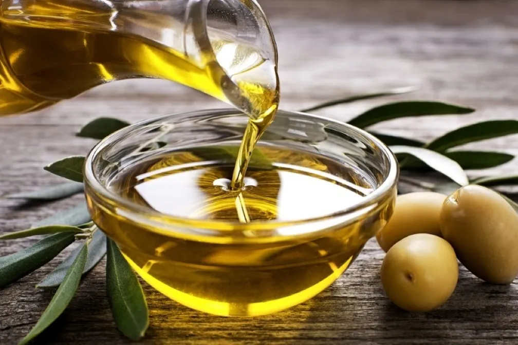 Aceite de oliva virgen extra servido con verduras para aprovechar sus grasas saludables dentro de una alimentación equilibrada.