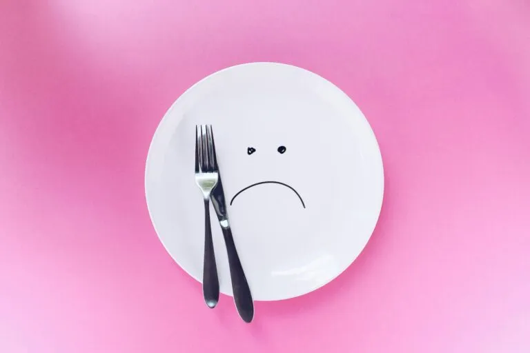 Mujer preparando una alimentación suficiente para perder grasa sin perder músculo y complementar su ejercicio de fuerza.