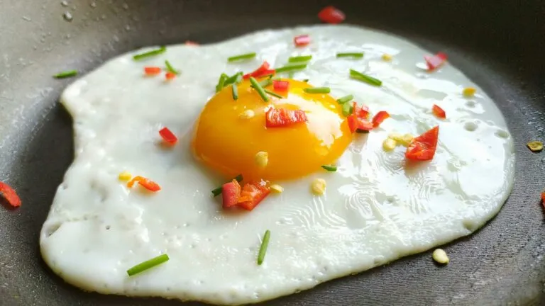 Huevos con gambones, papas doradas y verduras servidos como una cena rápida con proteína y una cantidad moderada de aceite.