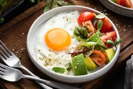 Desayuno después de los 50 con huevo cocido, pan integral y fruta fresca