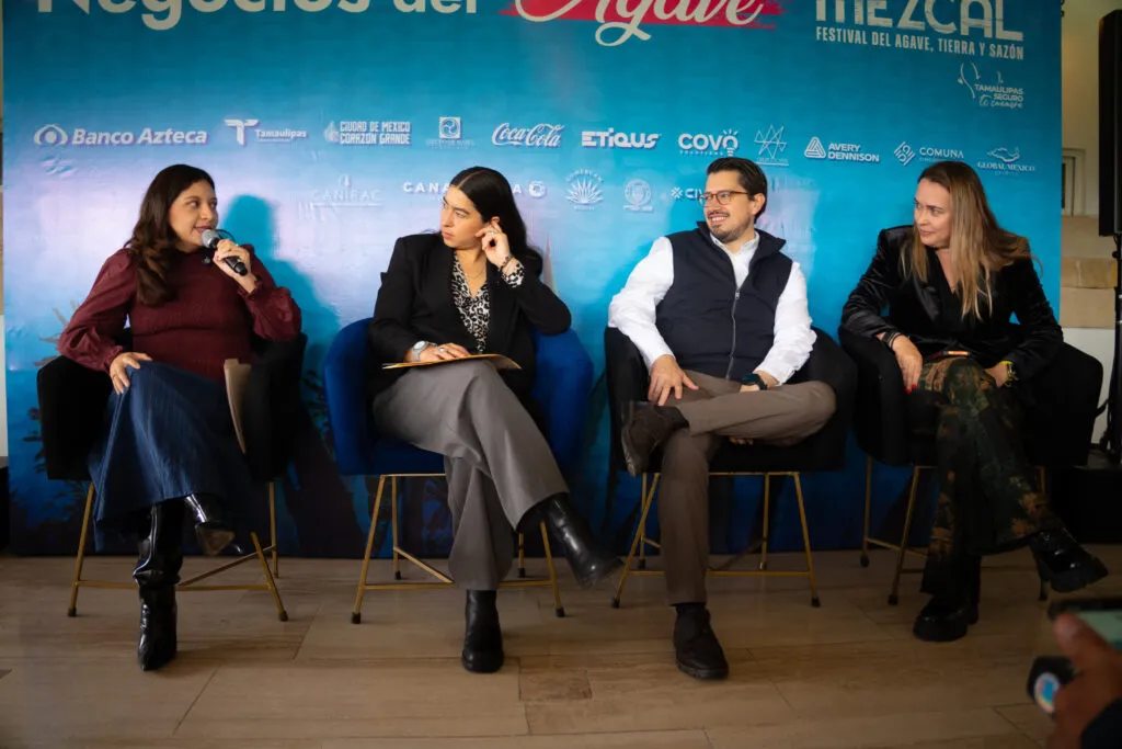 Cuatro participantes conversan durante un panel de Negocios del Agave en Mundo Mezcal, frente a un fondo con el logotipo de Banco Azteca.